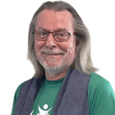 Porträt eines Mannes mit langen Haaren, Brille und grünem Shirt, der freundlich in die Kamera lächelt.
